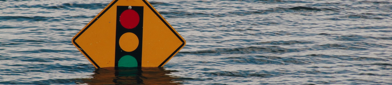 Traffic light road sign submerged in floodwater